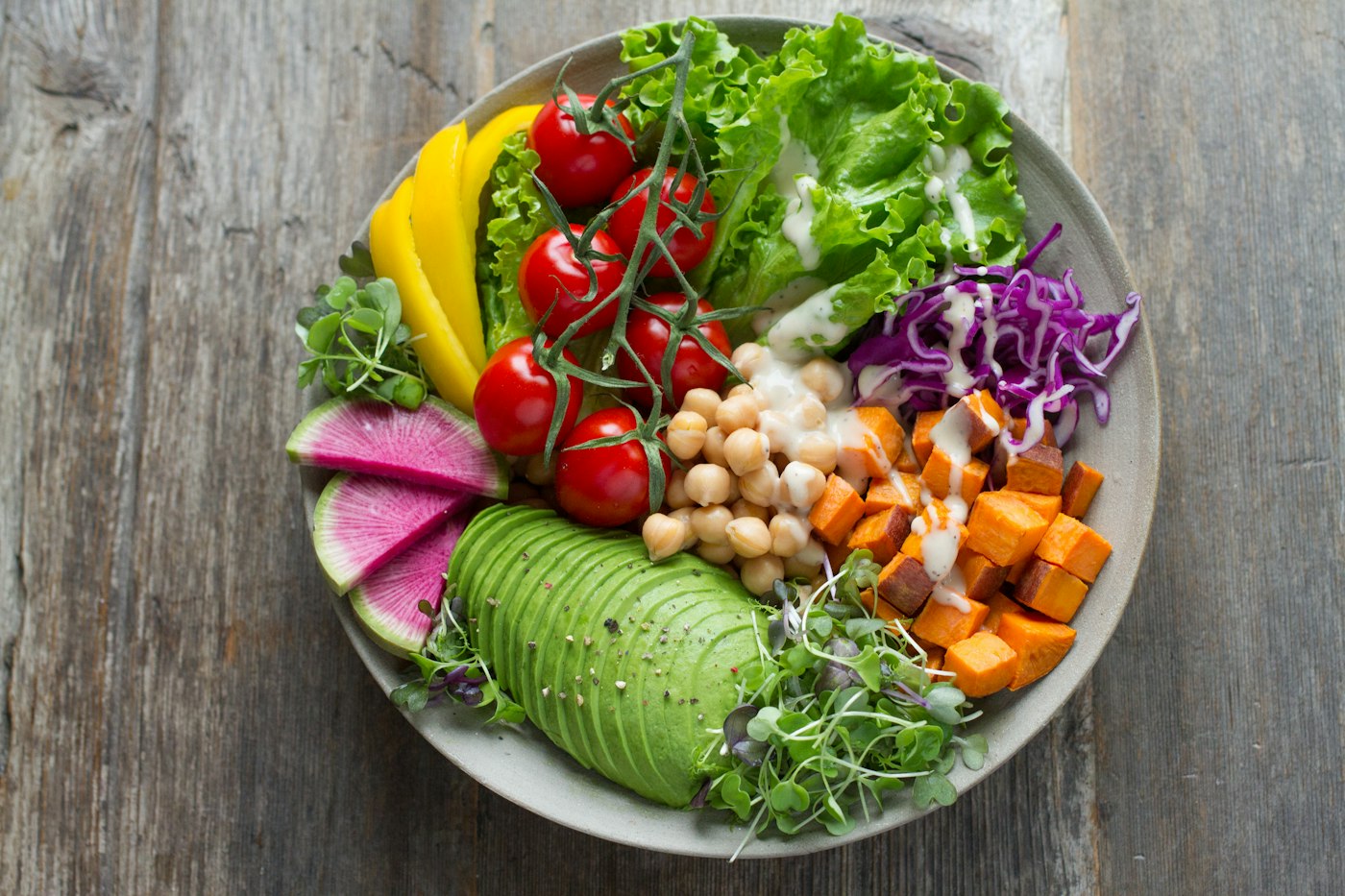 Salade composée vue de dessus : avocat, patate douce, pois chiches et tomates cerises